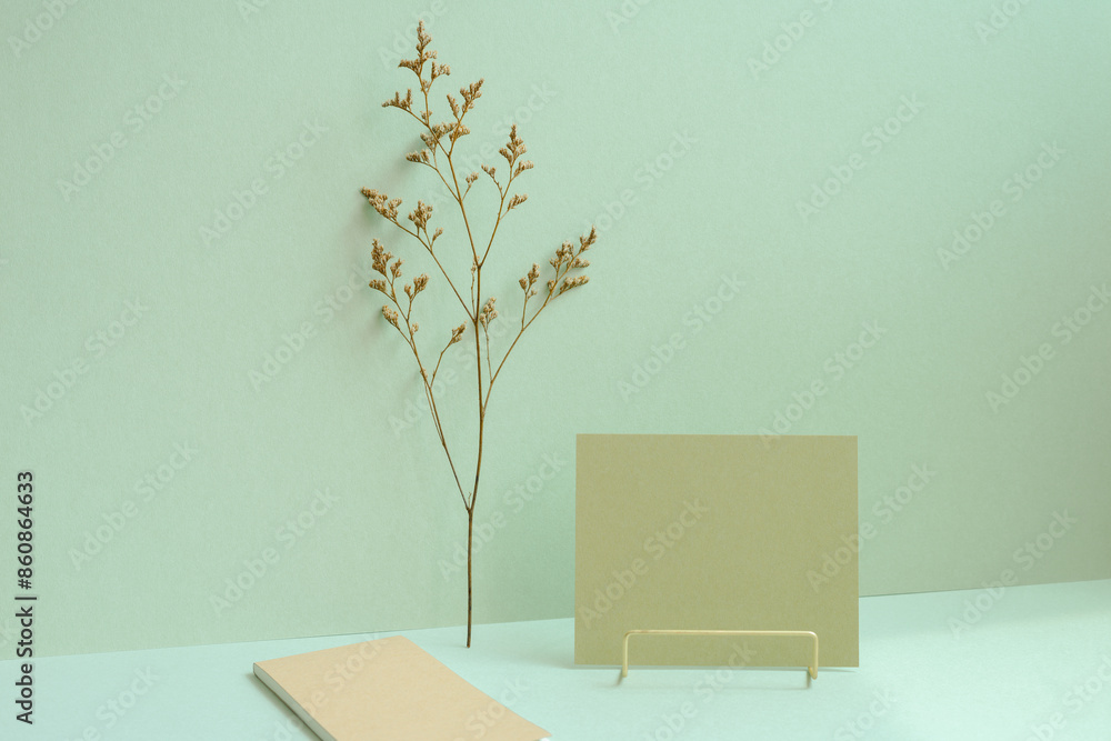 Workspace memo pad, note, dry flower on mint green desk background