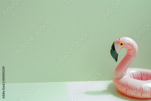 Obraz na płótnie Summer vacation concept. Pink flamingo bird shape swimming pool tube on mint green background w salonie