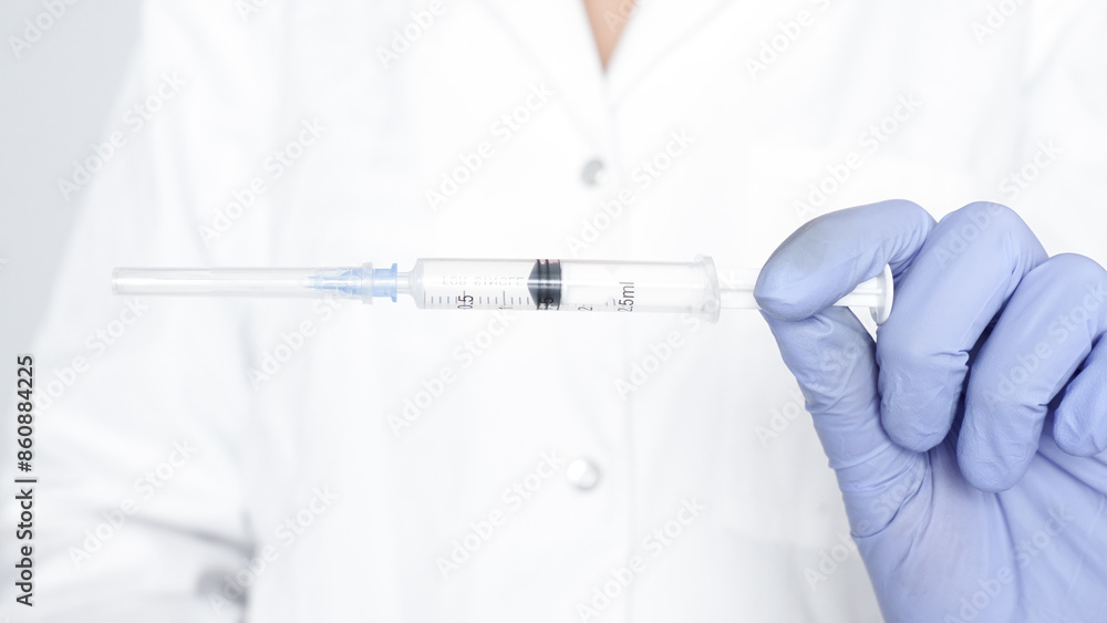 Gloved hand holding a syringe with a needle isolated on white background Gloved hand holding a syringe with a needle isolated on white background