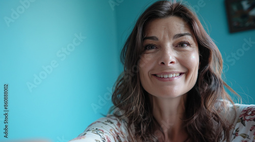 Obraz na płótnie Mother, approximately 45 years old, in a blue room, recording herself as a selfie, smiling at the camera w salonie