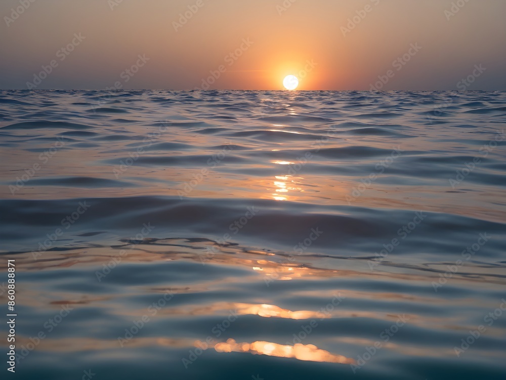 Obraz premium A clear blue ocean that stretches infinitely with a sky the color of a beautiful afternoon with the setting sun reflecting off the water.
