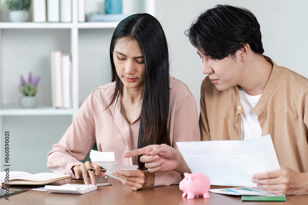 Young Couple Planning savings financial at Home with Documents and bills in a Modern Living Room Young Couple Planning savings financial at Home with Documents and bills in a Modern Living Room