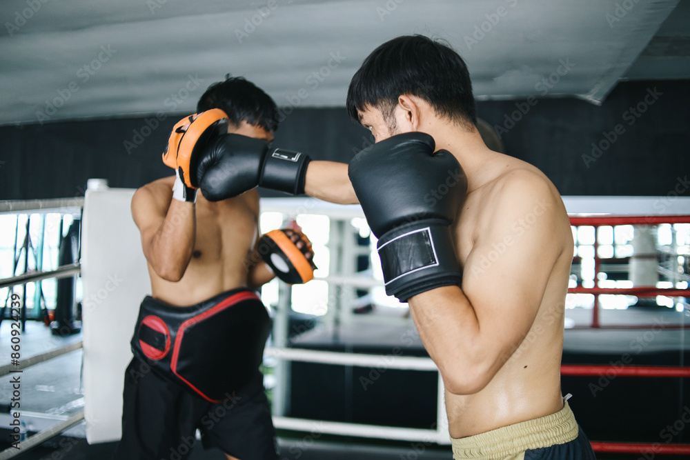 Potrait Of Asian Boxer Man Exercising Power Punch Wear Training Equiment In Boxing Arena Training Potrait Of Asian Boxer Man Exercising Power Punch Wear Training Equiment In Boxing Arena Training