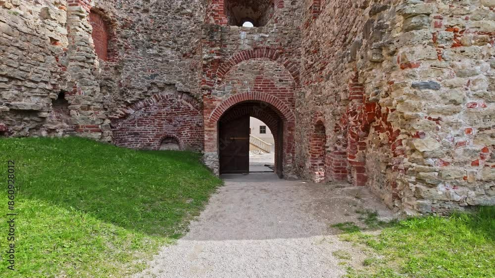 Establishing front dolly to Bauska Castle archway and wooden doors along gravel path
