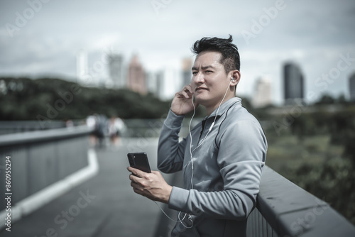 sport man listen music earphone and use smartphone Fitness application, social media, listening to music. Health and Lifestyle in big city life concept.