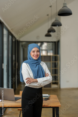 Small business startups, SME owners, Muslim female entrepreneurs Islam stood smiling, arms crossed, confident in his work at the office. independent business idea.