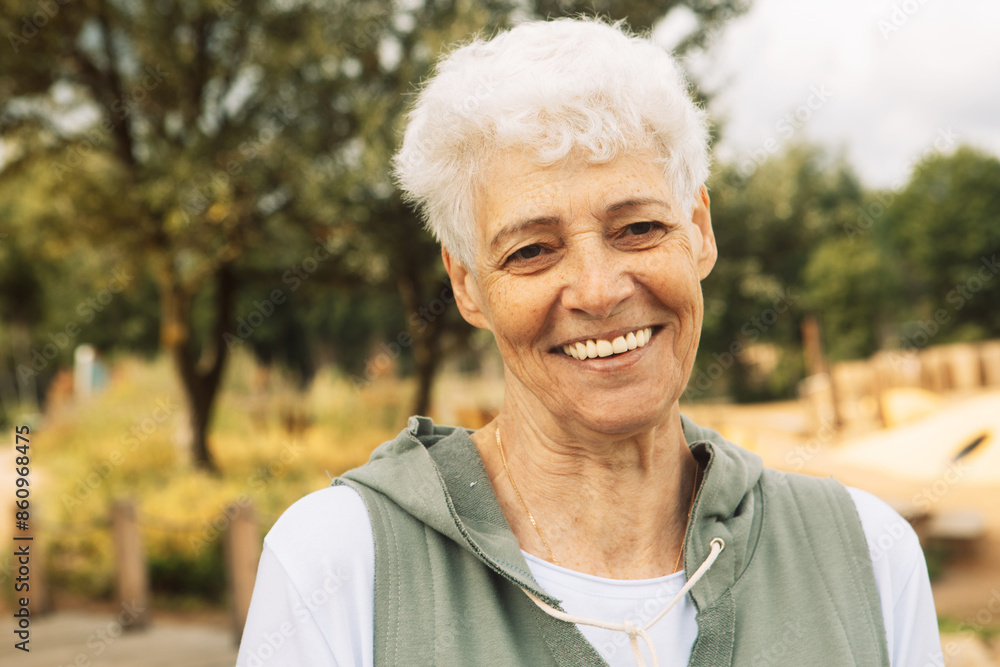 Portrait of smiling elderly woman at park. Close up portrait. Happy thoughful mature woman relaxing outdoor. Portrait of smiling elderly woman at park. Close up portrait. Happy thoughful mature woman relaxing outdoor.