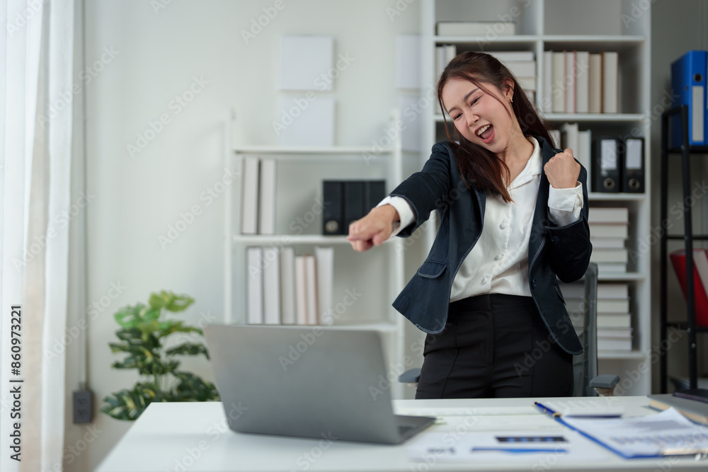 Successful businesswoman, happy, showing fighting pose Dancing after receiving news Successful business approval results on laptop in office Startup business idea, time online. Successful businesswoman, happy, showing fighting pose Dancing after receiving news Successful business approval results on laptop in office Startup business idea, time online.