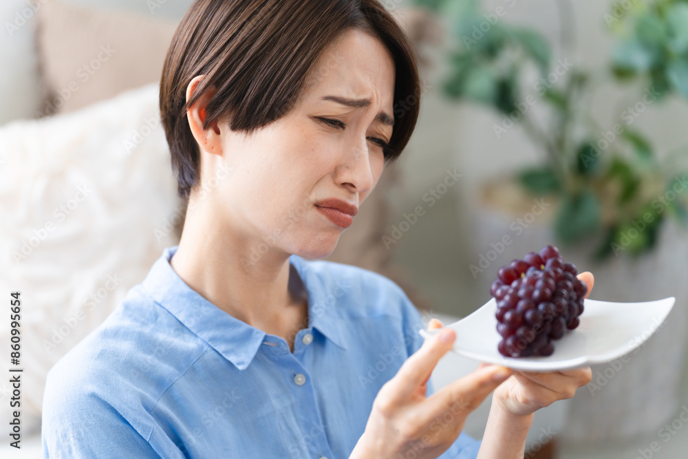 ブドウを食べる若い女性　ライフスタイルイメージ