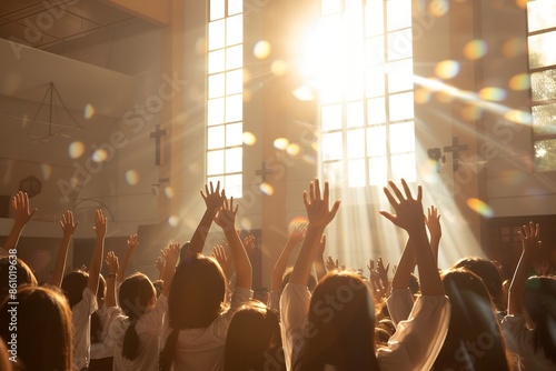 At the bright church, people raised their hands and galaxies filled with light surrounded them. The sun shone through large windows on students in class uniform who were raising their arms to give pra photo