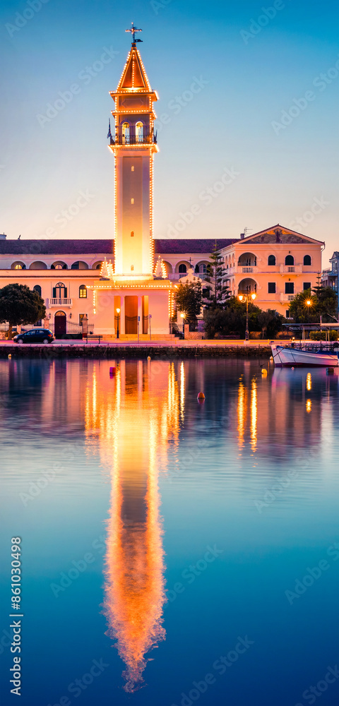 Fototapeta premium Picturesque spring sunset in the Zakynthos city. Great evening view of the town hall and Saint Dionysios Church, Ionian Sea, Zakynthos island, Greece, Europe. Traveling concept background.