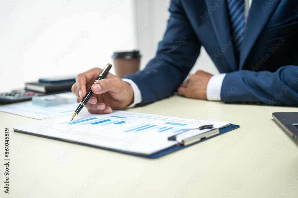 A banker in a suit works at a desk handling loans, analyzing client financial data, providing financial advice, dealing with stocks and the stock market, and studying economic situations. A banker in a suit works at a desk handling loans, analyzing client financial data, providing financial advice, dealing with stocks and the stock market, and studying economic situations.