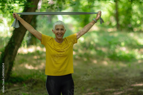 Senior woman strengthens muscles using elastic resistance bands for an effective workout. photo
