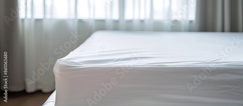 Bed corner with white fitted sheet. White sheet with elastic band. Bed cover close up photo. with copy space image. Place for adding text or design