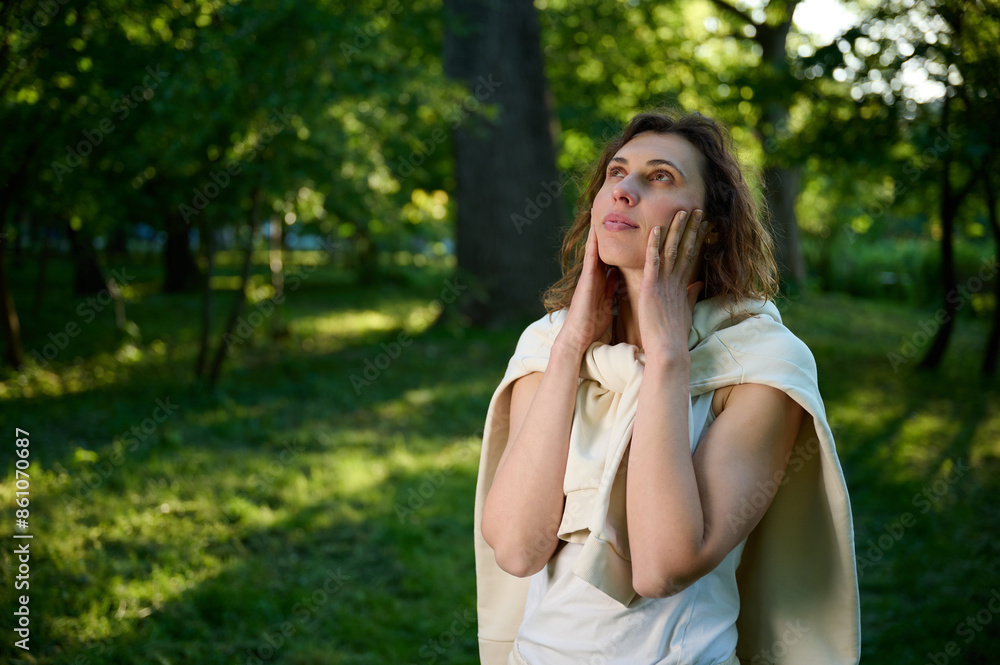 Young pretty woman in white modern casual clothes walking in the park, wandering around in nature and relaxing. Cute girl in white hoodie. Young pretty woman in white modern casual clothes walking in the park, wandering around in nature and relaxing. Cute girl in white hoodie.