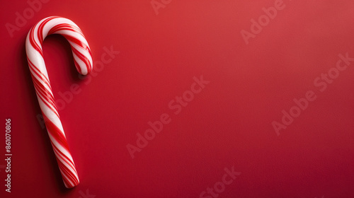 A single candy cane on a red background. photo