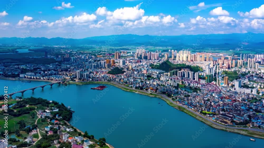 Aerial drone view of modern city financial district skyline and natural scenery with green river with bridges, greenery, landmark buildings, skyscrapers in the distance Aerial drone view of modern city financial district skyline and natural scenery with green river with bridges, greenery, landmark buildings, skyscrapers in the distance