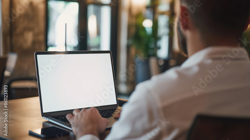 Businessman working on laptop with white screen in cafe