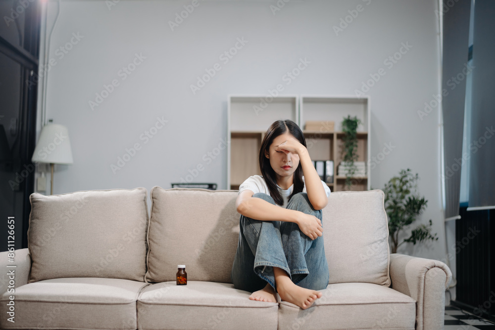 Asian woman sit Depression Dark haired pensive glance Standing by window and anxiety Copy space with a blanket on a sofa. Asian woman sit Depression Dark haired pensive glance Standing by window and anxiety Copy space with a blanket on a sofa.