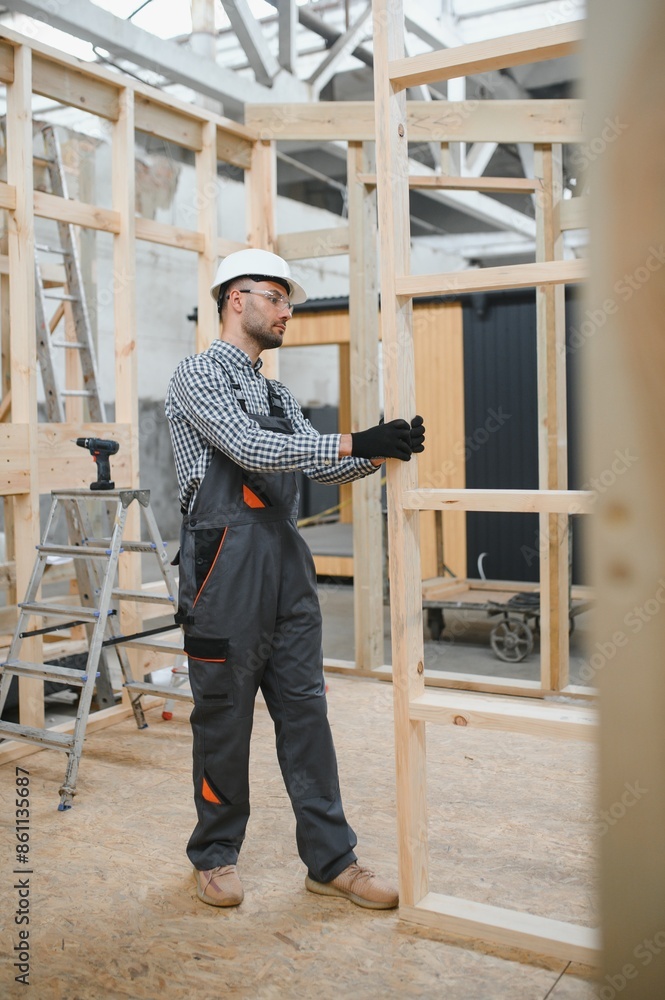 Process of construction new and modern modular house. Worker man in special protective uniform wear working on building development industry of energy efficient property Process of construction new and modern modular house. Worker man in special protective uniform wear working on building development industry of energy efficient property