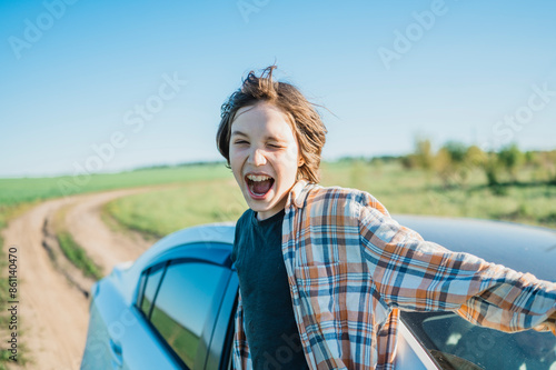 Happy boy looking out of car window photo