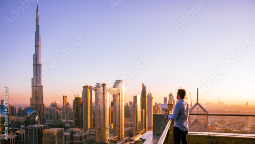 Man looking to Dubai sunset with views to the city centre from a skyscraper