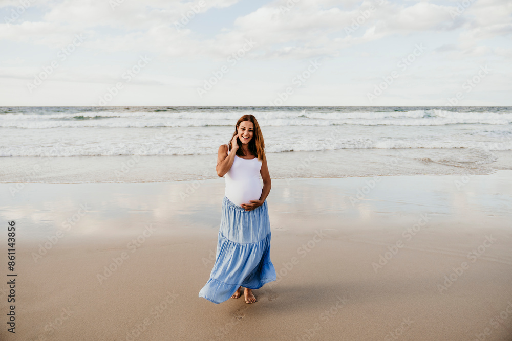 Happy pregnant woman standing near sea at beach Happy pregnant woman standing near sea at beach