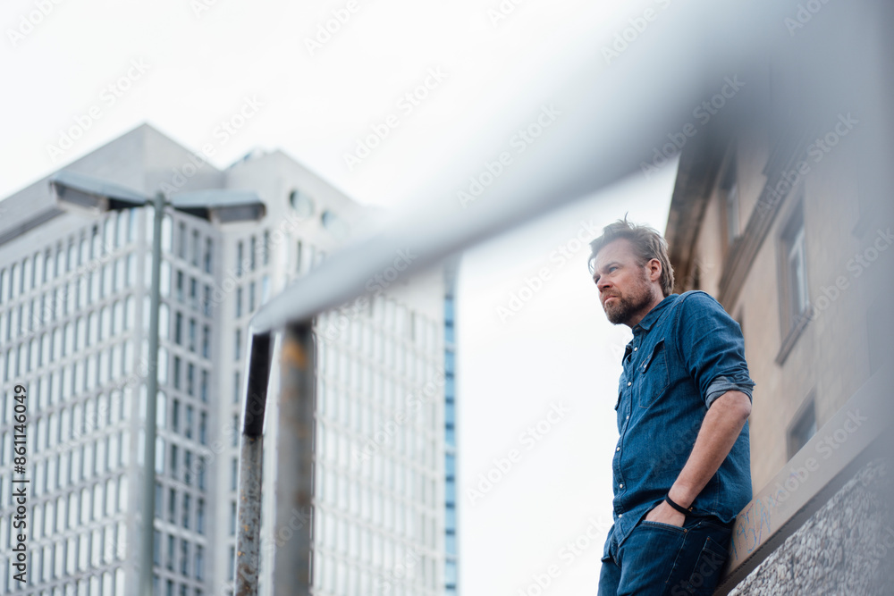 Businessman with hands in pockets by buildings Businessman with hands in pockets by buildings