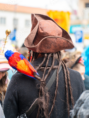 People in carnival. a man in a pirate costume with a parrot on his shoulder in the public space