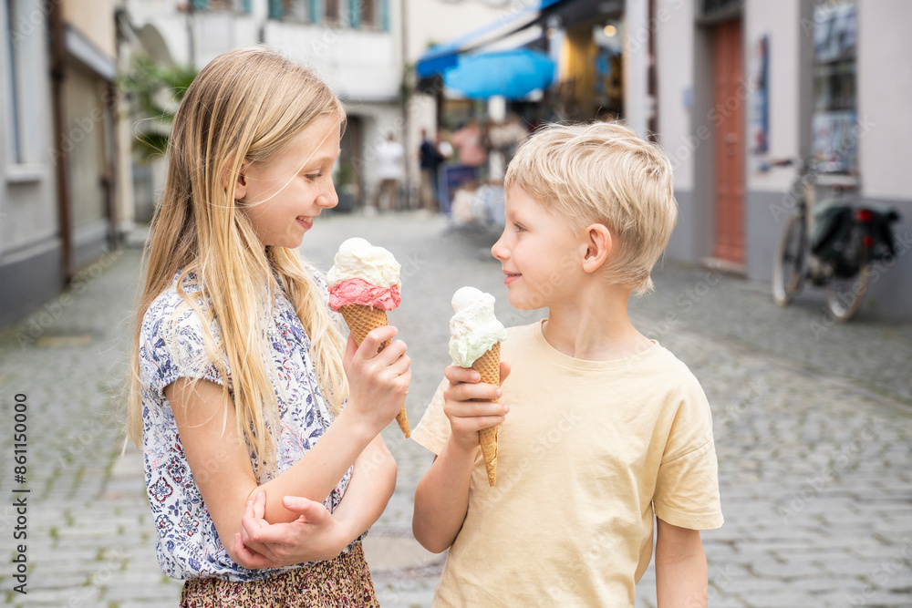Happy brother and sister enjoying ice cream in city Happy brother and sister enjoying ice cream in city