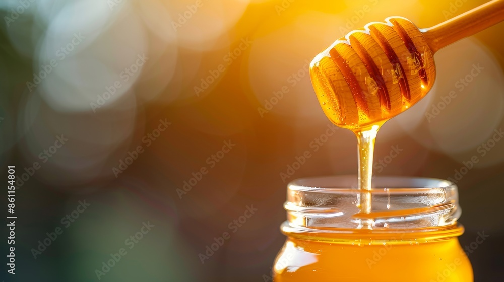 golden honey dripping from dipper into jar on blurry background. golden honey dripping from dipper into jar on blurry background.
