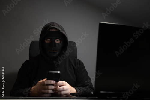 Hacker, man in mask with laptop, criminal, security threat, cyberspace.