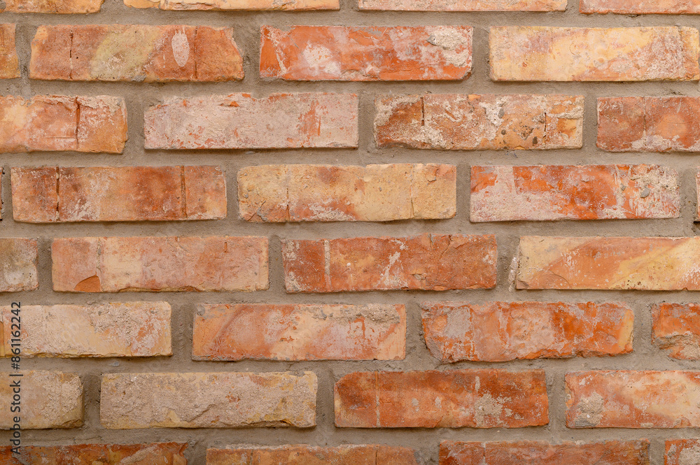 Obraz premium Sciana z pomarańczowych starych prostokątnych niedoskonałych cegieł z bliska, ceglaste tło