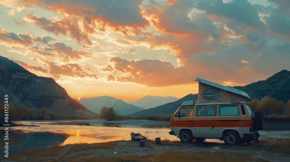 Fototapeta premium Campervan holiday in front of the river with mountains in the background, parked next to the river.