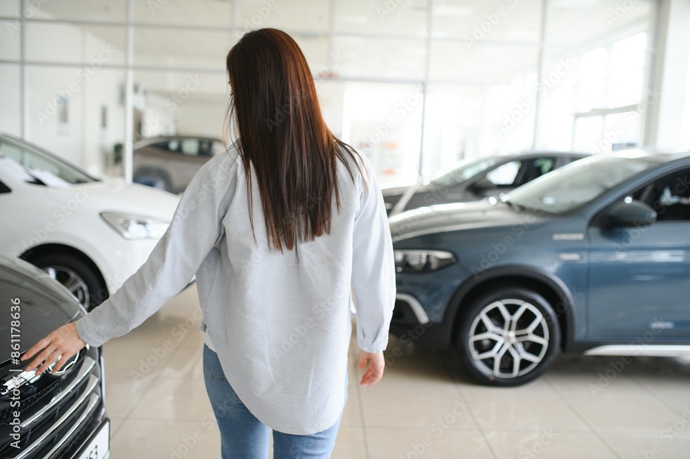 Beautiful young female client customer choosing new car Beautiful young female client customer choosing new car