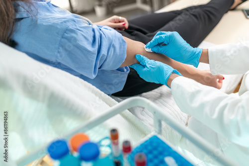 Healthcare worker drawing blood from a patient in a hospital room.