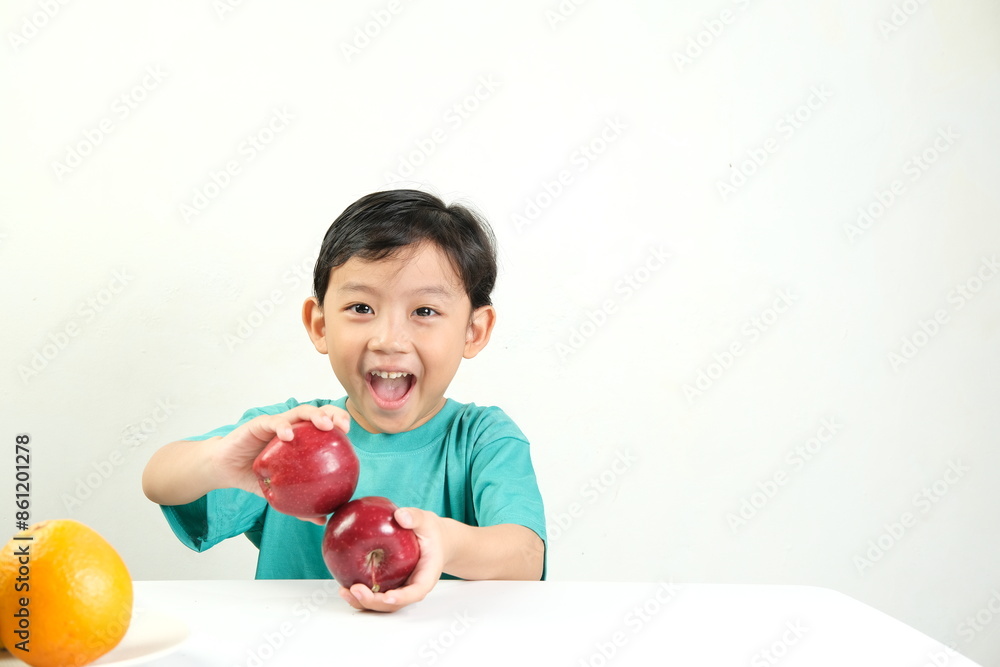A cheerful young boy in green shirt holding two red apples and smiling brightly.The image conveys joy,healthy eating, and the freshness of fruits,perfect for promoting nutrition and healthy lifestyles A cheerful young boy in green shirt holding two red apples and smiling brightly.The image conveys joy,healthy eating, and the freshness of fruits,perfect for promoting nutrition and healthy lifestyles