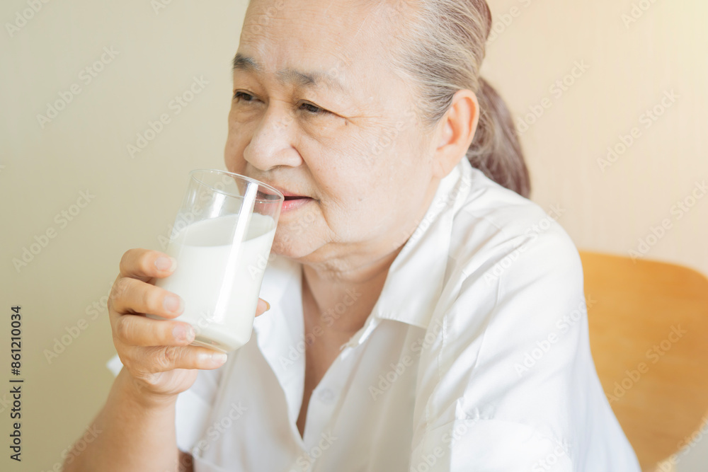 Asian senior mature aged woman drinking milk for calcium food and healthy.