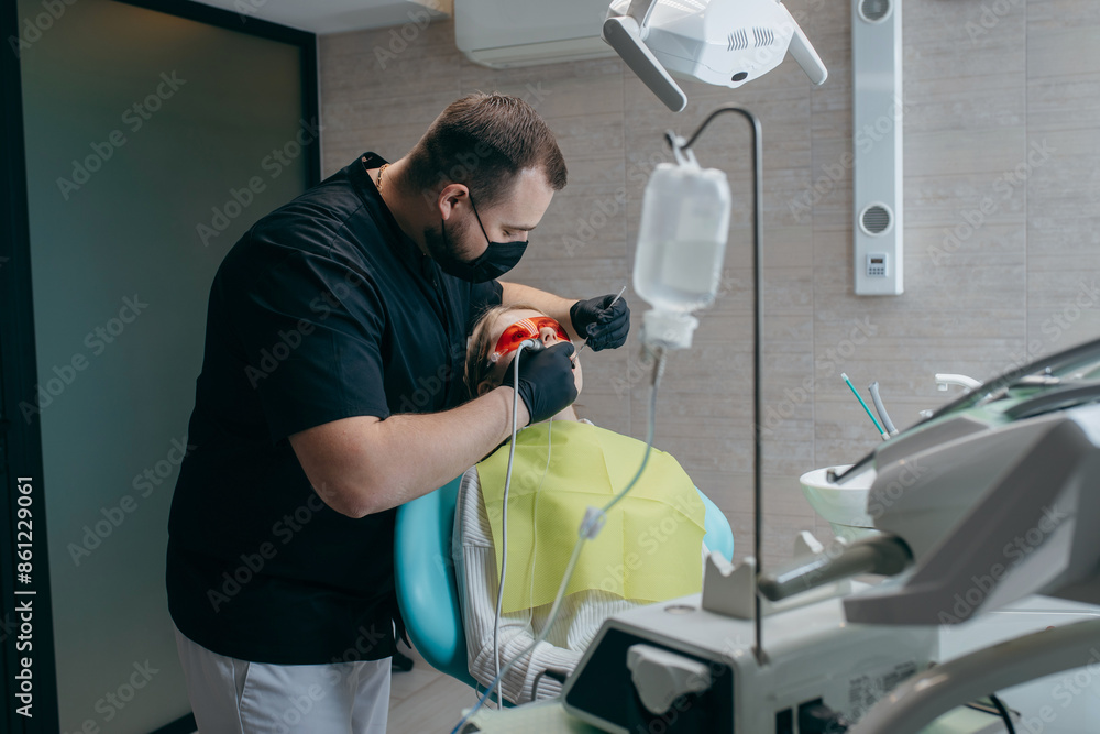 Dentist inserts an implant into a girl Dentist inserts an implant into a girl