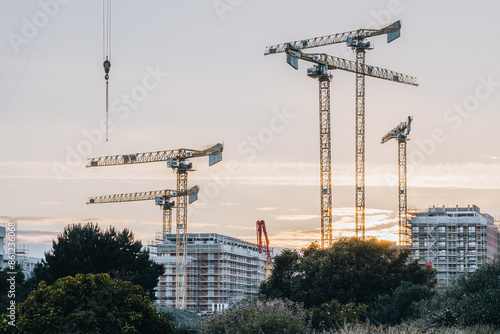 Construction Cranes at Sunset in Dublin with Modern Buildings and Scenic Evening Sky
