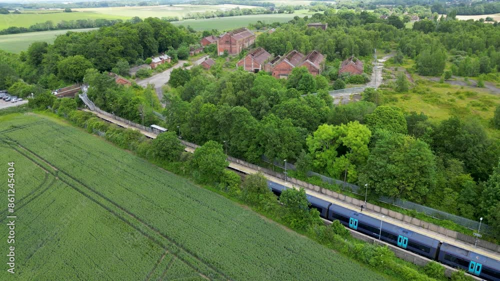 Blue South Eastern train pulling slowly into a village trains station in the countryside with some abandoned buildings in the background. Blue South Eastern train pulling slowly into a village trains station in the countryside with some abandoned buildings in the background.