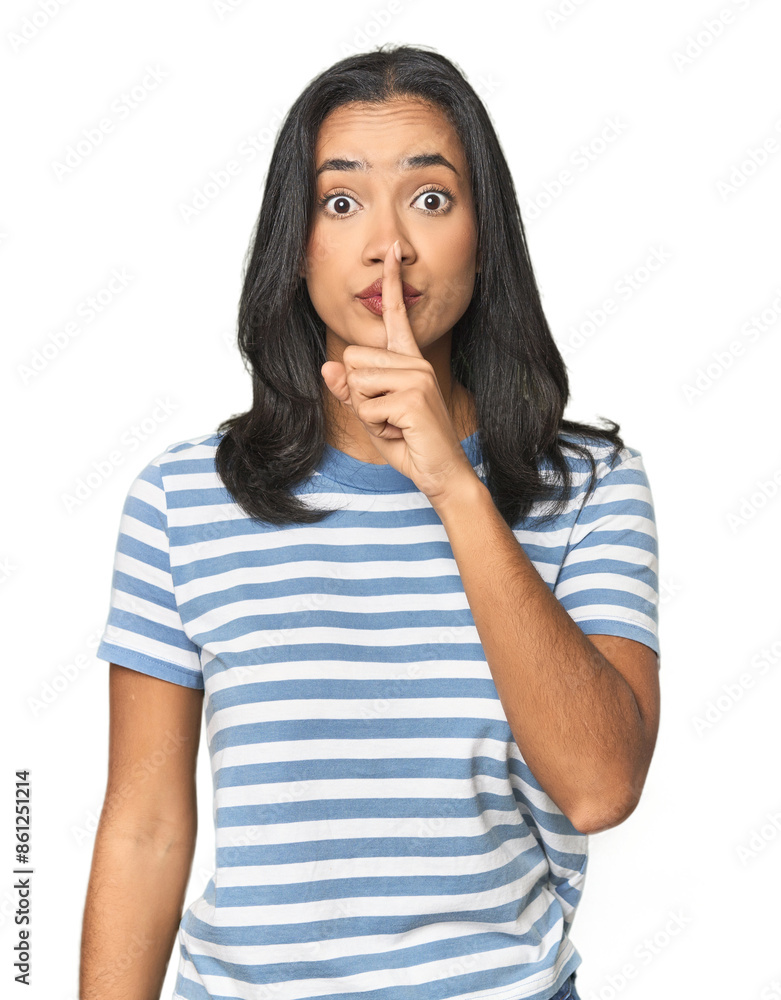 Young Latina posing in studio keeping a secret or asking for silence. Young Latina posing in studio keeping a secret or asking for silence.