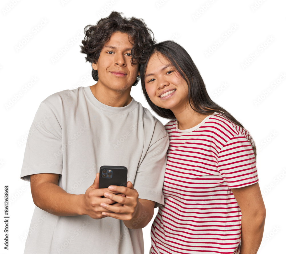 Fototapeta premium Young interracial couple using smartphone happy, smiling and cheerful.