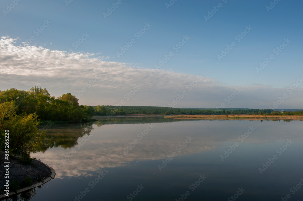 Beautiful panorama of autumn lake against the background of forest and sunny sky Beautiful panorama of autumn lake against the background of forest and sunny sky
