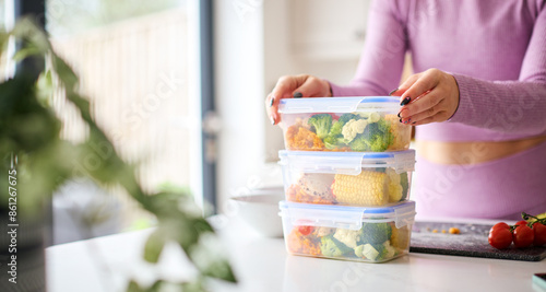 Close Up Of Woman Wearing Fitness Clothing At Home In Kitchen Making Healthy Meals For The Freezer