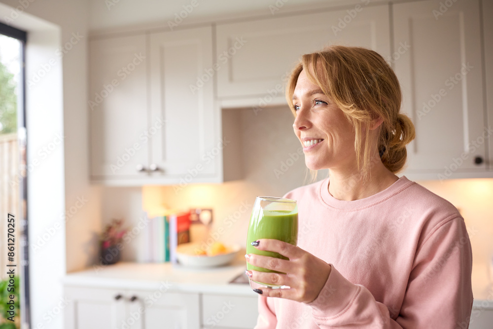 Woman Drinking Fresh Healthy Homemade Smoothie From Glass In Kitchen At Home Woman Drinking Fresh Healthy Homemade Smoothie From Glass In Kitchen At Home