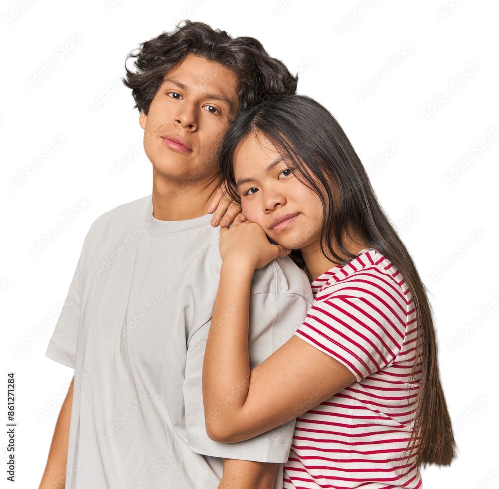 Happy multiracial couple hugging and looking at camera in studio Happy multiracial couple hugging and looking at camera in studio
