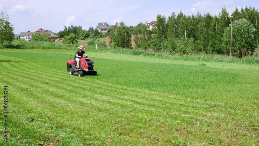 Man on lawn tractor mowing lawn on backyard. The red rider. The lawnmower tractor. High quality 4k footage Man on lawn tractor mowing lawn on backyard. The red rider. The lawnmower tractor. High quality 4k footage
