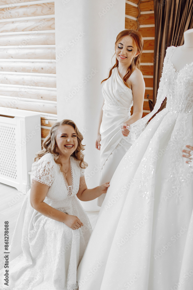 A woman is sitting on the floor next to a woman in a white dress A woman is sitting on the floor next to a woman in a white dress