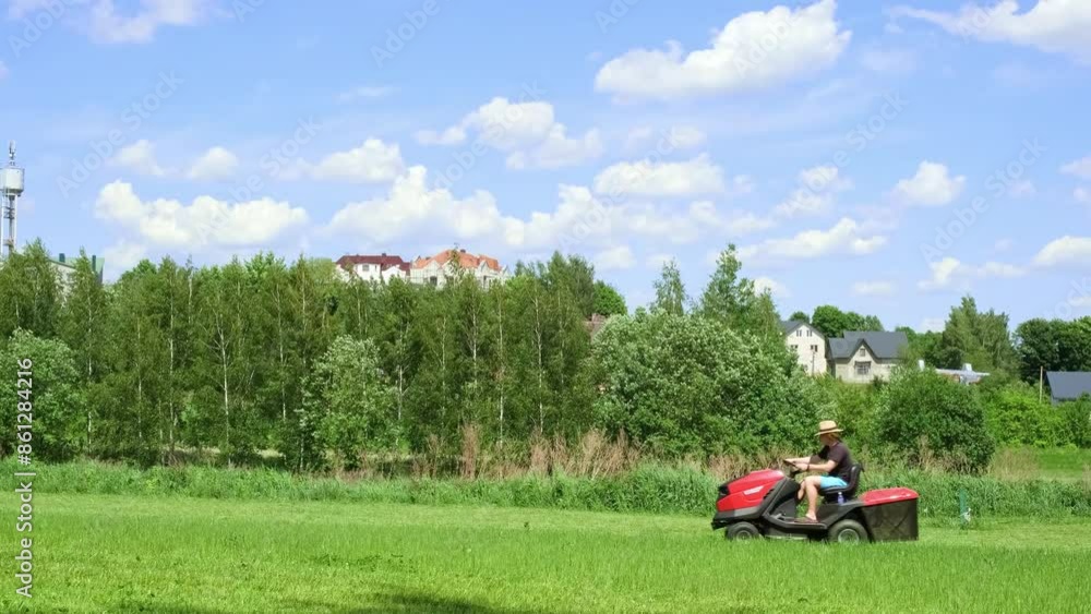 Man on lawn tractor mowing lawn on backyard. The red rider. The lawnmower tractor. High quality 4k footage Man on lawn tractor mowing lawn on backyard. The red rider. The lawnmower tractor. High quality 4k footage